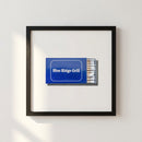 High-resolution image of Blue Ridge Grill framed print mounted on white wall, showcasing natural wood frame and soft lighting.