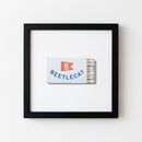 High-resolution close-up of Beetlecat framed print emphasizing textured paper, matte black frame, and warm lighting for detailed view.