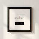 High-resolution photograph of the framed Chicago Athletics Association poster on a white wall, highlighting its micro-texture, glossy and matte finish, and oak wood frame in a cozy setting.