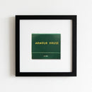 Portrait of the Armour House framed poster on a plain white wall in a cozy home, highlighting high-quality paper and wood texture with natural warm light.