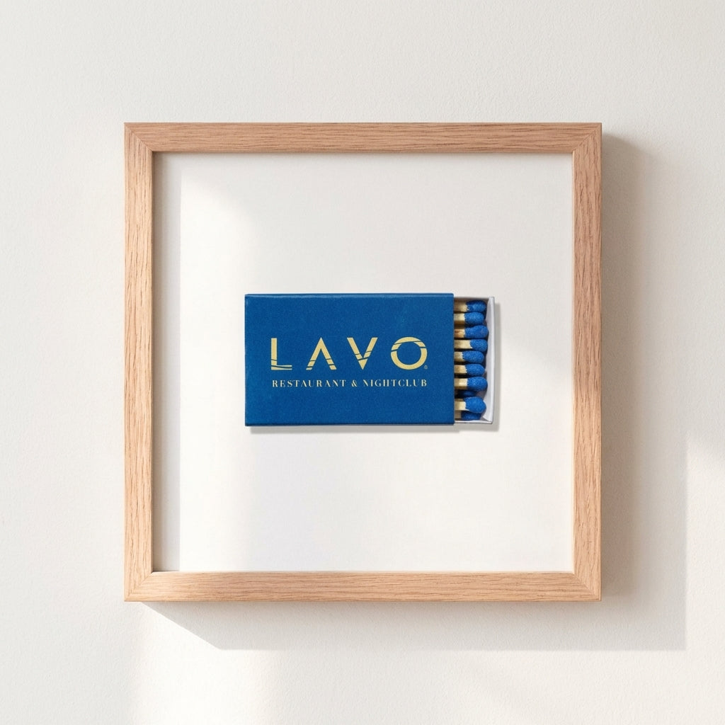 Detailed close-up of black framed print on white wall, soft warm lighting emphasizing textured surface and finish.