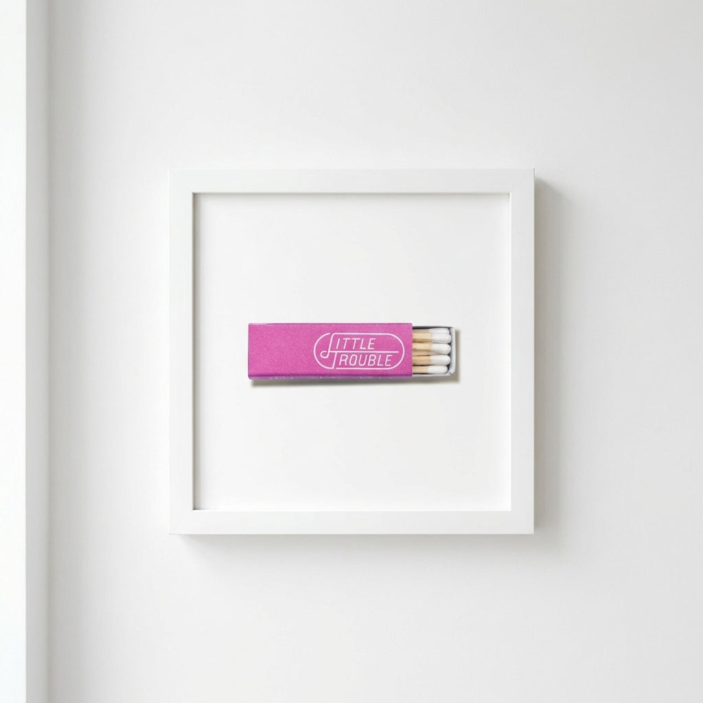 Elegant close-up of the Little Trouble framed print on a white wall, highlighting textured matte paper and sleek wooden frame.
