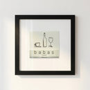 Framed 'Babas on Cannon' print hanging on a white wall in a cozy living room scene with warm natural lighting.