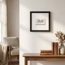 Framed Halls print hanging on a white wall in a cozy living room with warm natural light, detailed textured paper and wood frame.