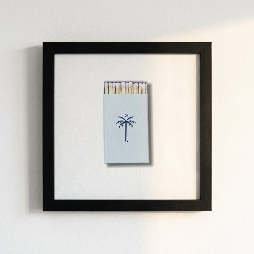 Full view of 'Island Provisions' framed print on a white wall in a warm, inviting space with natural sunlight highlighting the matte black frame and high-quality paper.
