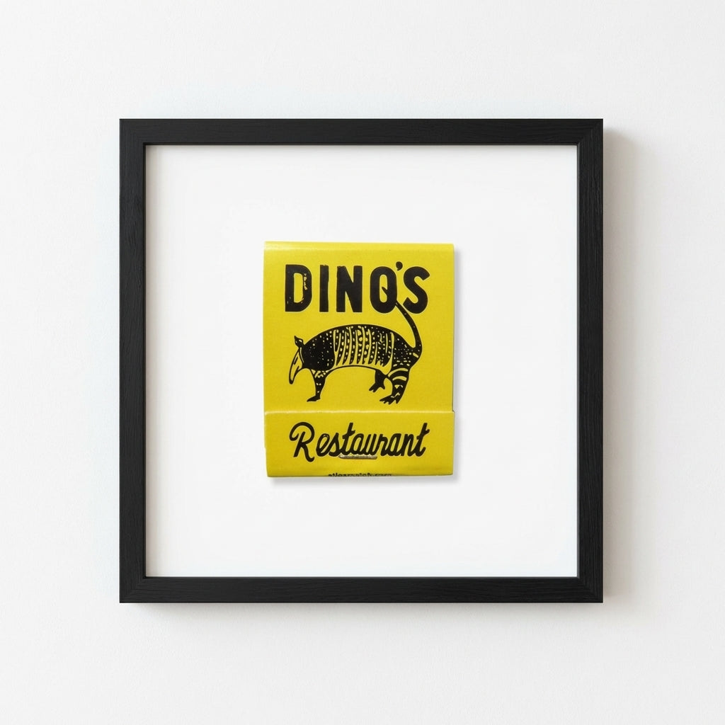 Lifelike 'Dino's' framed poster mounted on a white wall in a relaxed room with warm natural sunlight, showcasing rich colors and textured paper.