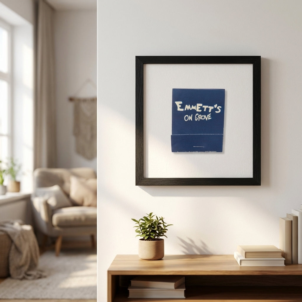 Full-body view of 'Emmett’s on Grove' framed poster on white wall in a warm, cozy living space with natural light and subtle interior details.