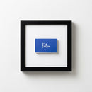 Framed Felix print hanging on a white wall in a cozy, natural-lit room, highlighting textured paper and wood frame.