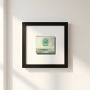 Elegant Golden Eagle framed print in black wooden frame, displayed on a neutral wall with warm lighting emphasizing its textured matte paper.