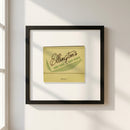 14x14 inch Ellington’s poster hanging on a white wall in a cozy room, with natural warm sunlight highlighting the wooden frame, paper quality, and protective Acrylite.