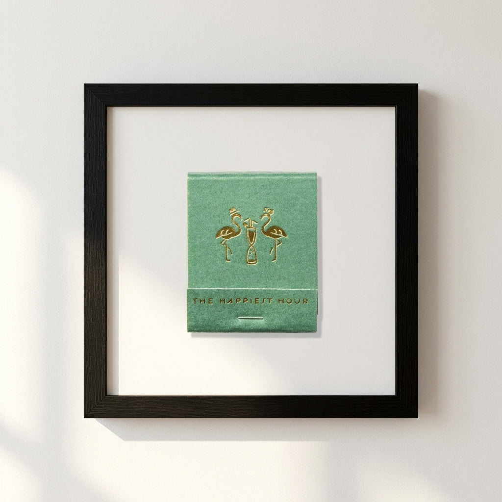 High-resolution image of The Happiest Hour Matchbox framed print on a white wall with warm natural light, highlighting the woodgrain and textured paper finish.