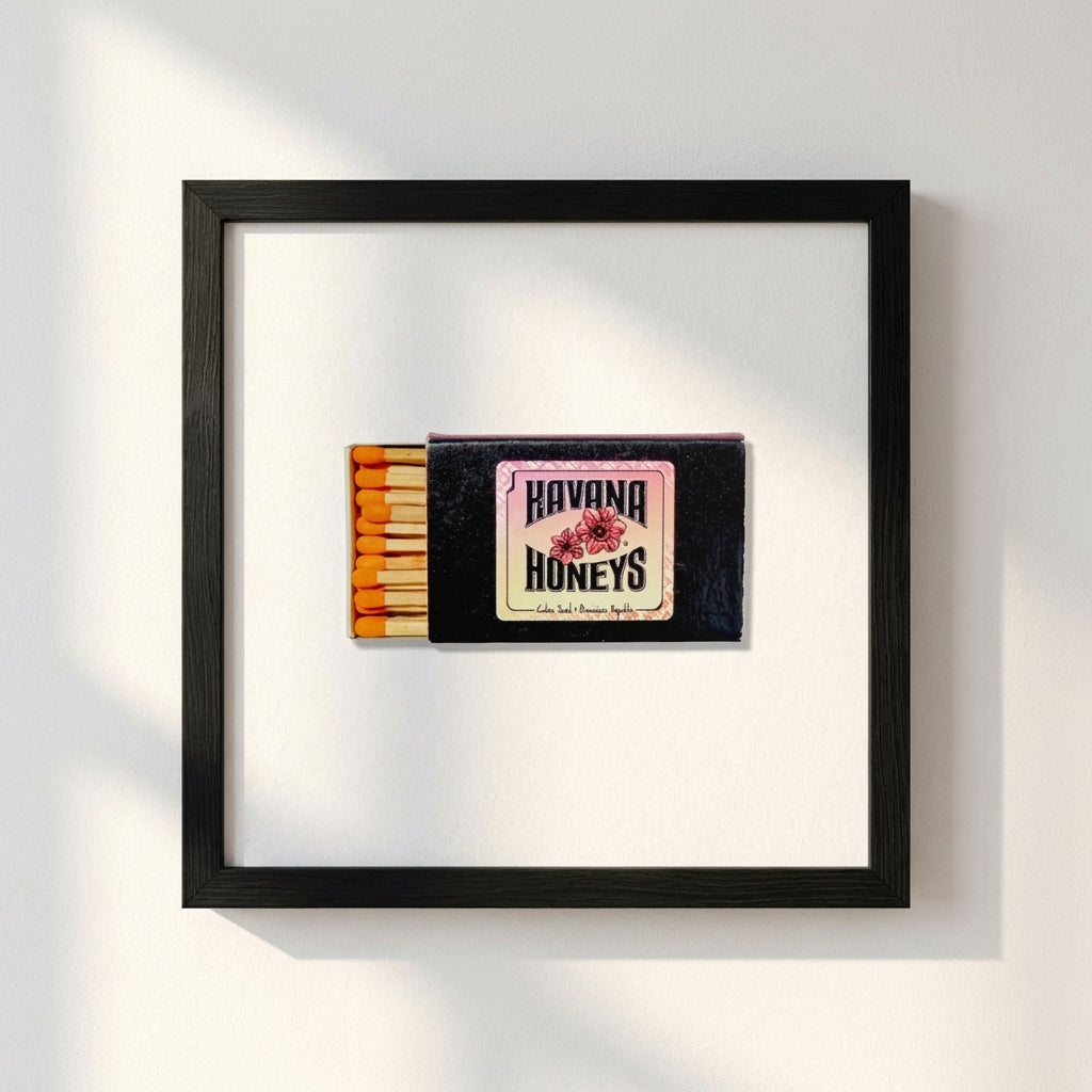 Professional photograph of Havana Honey's framed poster on a white wall, capturing warm natural light, textured paper, and smooth wooden frame.