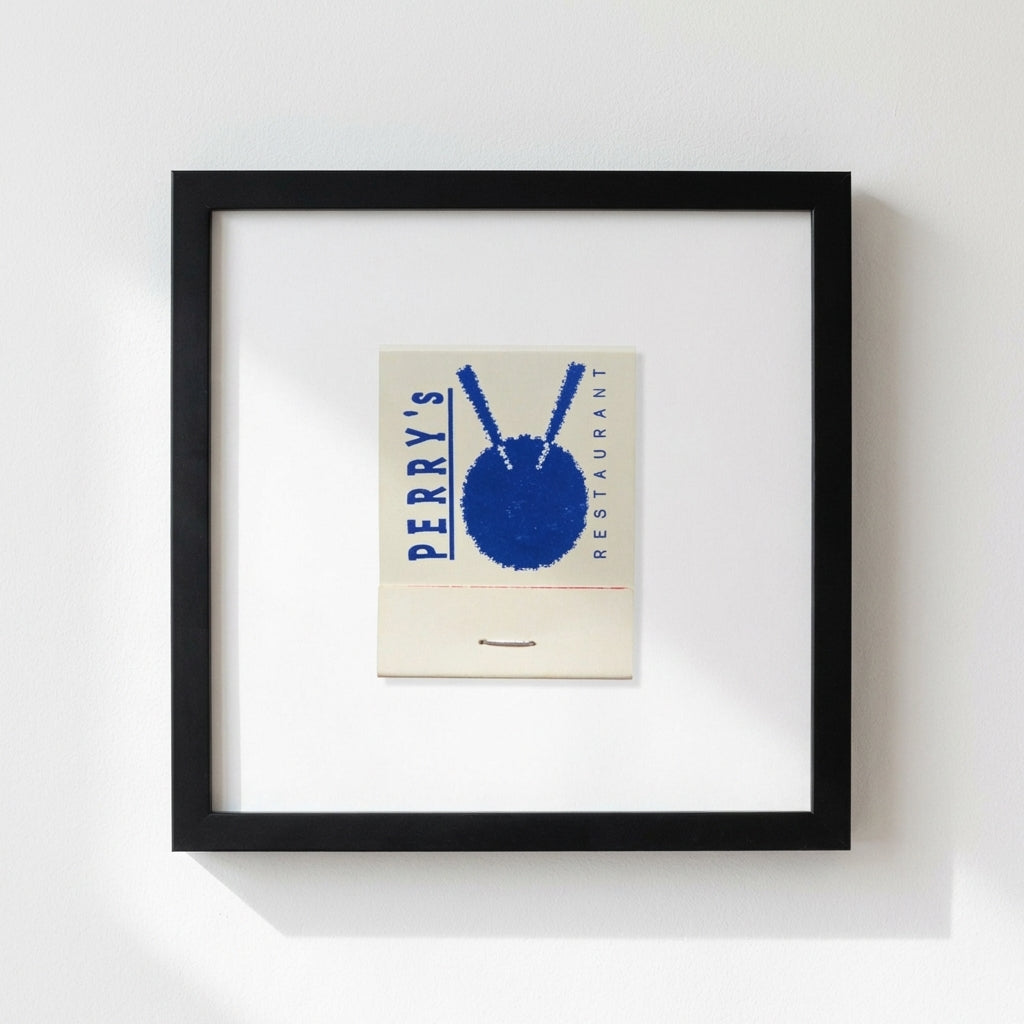High-resolution image of Perrys framed poster on white wall in a warm, inviting environment with realistic lighting and shadows