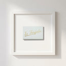 Elegant framed print of Le Farfalle on a white wall with natural warm lighting, showcasing high-quality paper and wood frame.