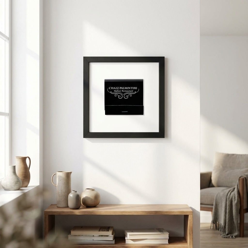 Full view of Chazz framed print hanging on a white wall in a warm, inviting living room, highlighting details of the black wood frame and acrylic protector.