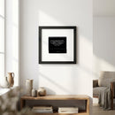 Full view of Chazz framed print hanging on a white wall in a warm, inviting living room, highlighting details of the black wood frame and acrylic protector.