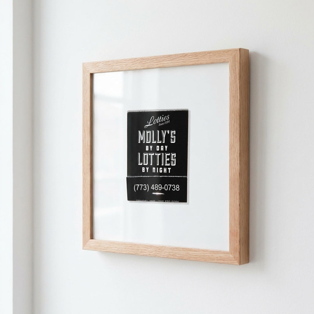 Lifestyle shot of 'Lottie's Chicago' framed poster in a warm living space with natural lighting, highlighting the high-quality paper, glass protector, and elegant wooden frame.
