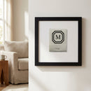 Close-up of Mark Hotel framed print on white wall in inviting living room with warm lighting and detailed wooden frame.