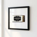 Framed print of Martin's Tavern on a wall, showcasing high-quality paper with glossy and matte finish, wood frame, acrylic protector, in a cozy room.
