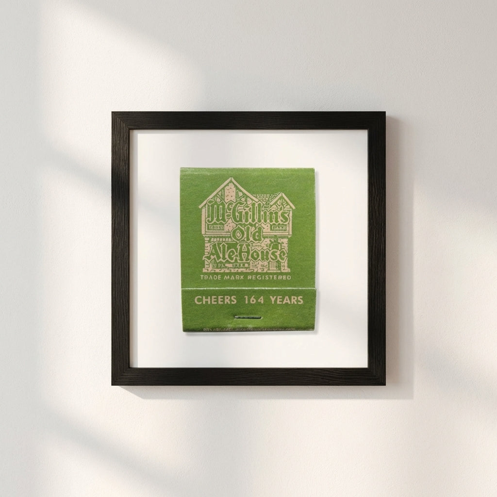 Full-body shot of McGillin’s Old Ale House framed poster mounted on white wall, highlighting craftsmanship and cozy interior ambiance.