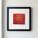 Realistic image of 'Old Ebbitt Grill' framed poster in minimalistic cozy room with natural light highlighting paper and wood frame.
