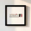 14x14 inch white frame of Quality Meats print with glossy matte finish mounted on a wall, illuminated by warm light.