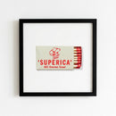 High-quality framed print of Superica on a wall, showcasing a partly glossy, matte paper finish in a warm, inviting setting.
