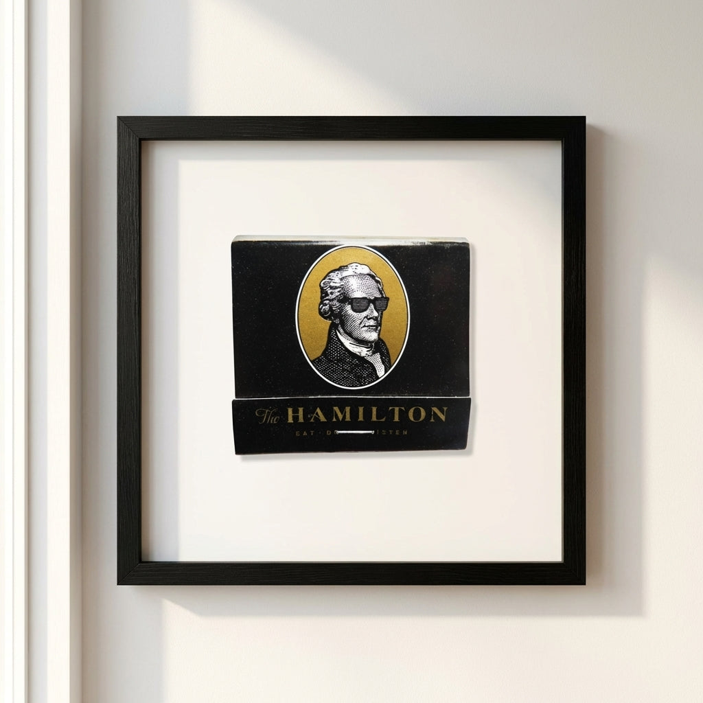 Close-up of The Hamilton framed poster highlighting micro-textural details and wood frame with soft natural lighting on a white background.