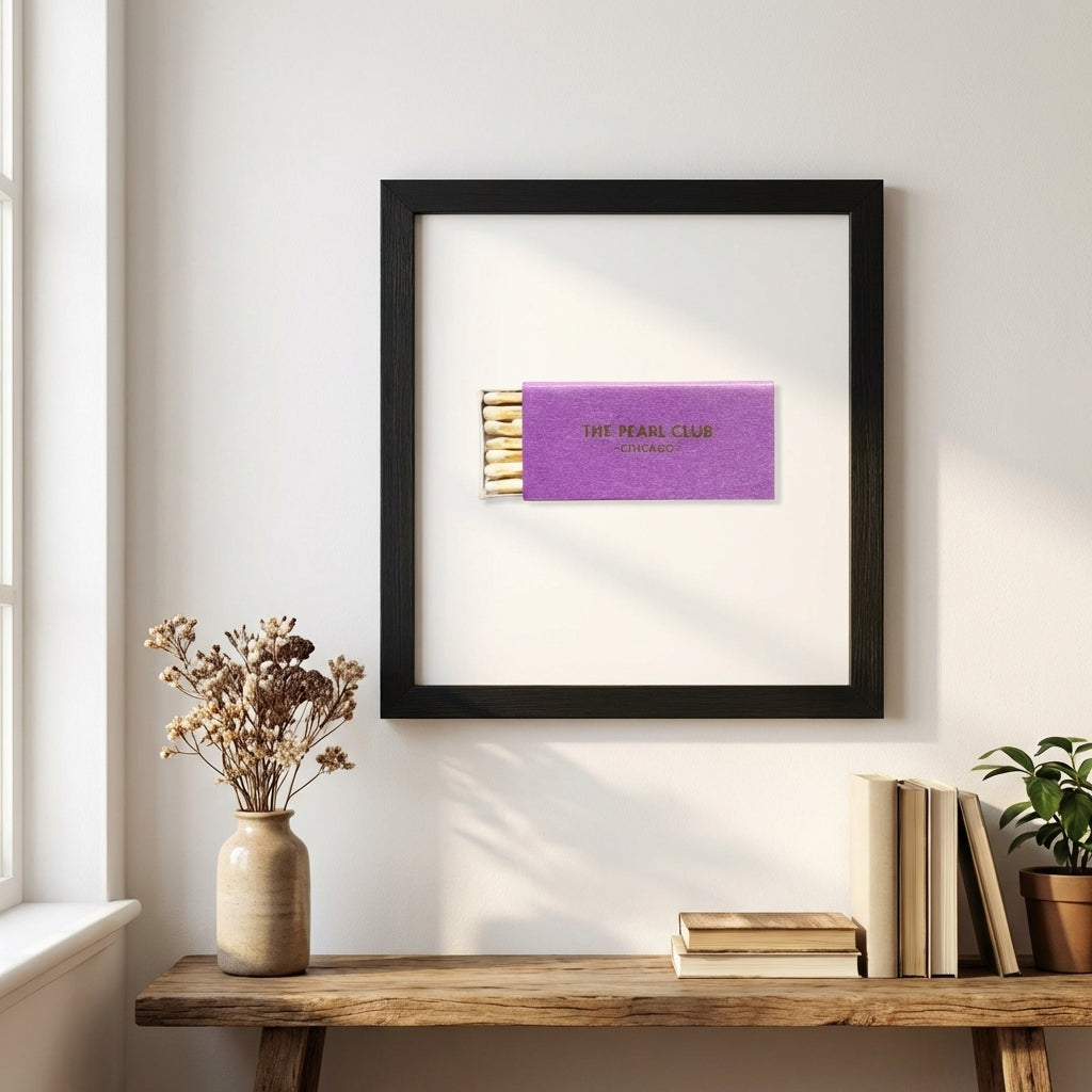 Full-body view of The Pearl Club framed poster on white wall in a modern cozy room, highlighting luxury-grade print and wooden frame details.