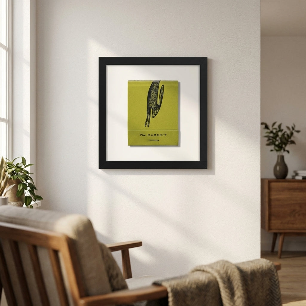 Crisp image of The Rarebit framed poster on a white wall, showcasing detailed paper texture and neutral wooden frame in a natural interior setting.