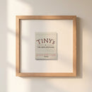 Elegant 10x10 inch Tiny’s Framed Print with ayous wood frame, hanging on a white wall in a cozy living room, natural lighting enhances details.