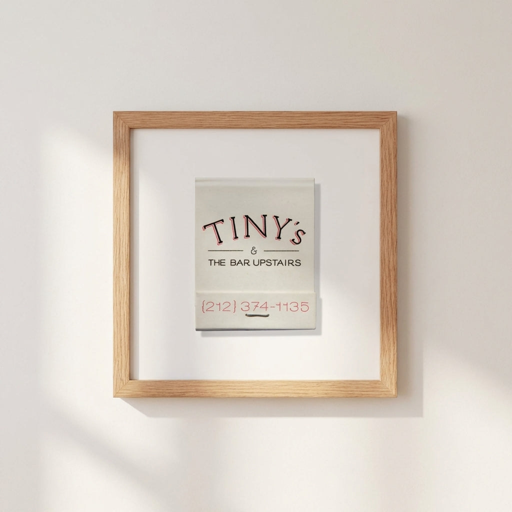 Full view of Tiny’s Framed Print mounted on a white wall in a warmly lit living space, highlighting the textured frame and print details.