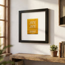 Crisp view of the 'Jane Jane' framed poster on a white wall in a bright living room with warm natural lighting and detailed wood frame.