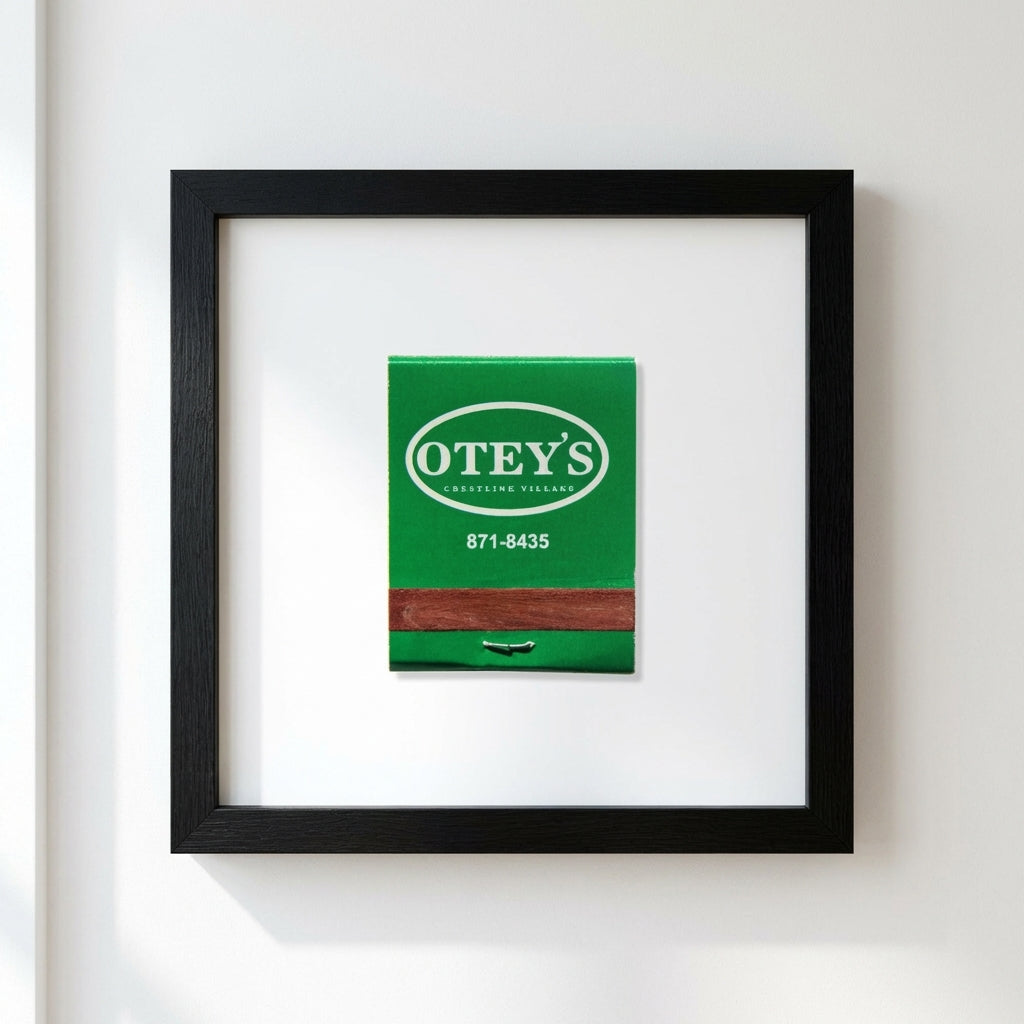 Full view of 'Otey’s' framed poster hanging on a plain white wall, emphasizing the detailed wood frame and premium paper with a soft, inviting light.
